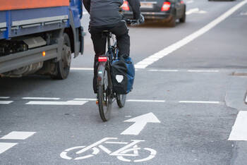 Fahrradfahrer fährt mit eingeschaltetem Rücklicht durch Straßenverkehr