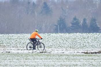 Fahrradfahrer fährt im Schnee