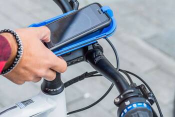Smartphone befindet sich in einer Halterung am Fahrrad.