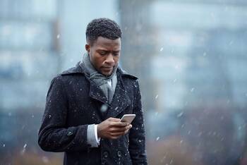 Person mit iPhone im Schneegestöber