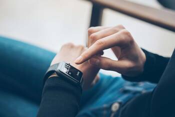 Person tippt auf Smartwatch am Handgelenk