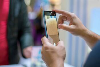 Eine  Person macht ein Foto mit einem Huawei P30 Pro. Im Hintergrund ist eine weitere Person erkennbar.