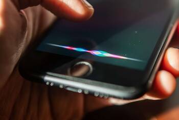 Hand hält iPhone mit aktivierter Siri-Funktion