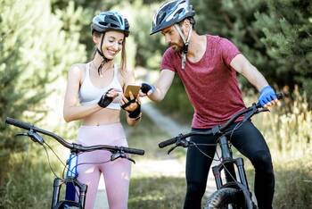 Mann und Frau gucken während einer Radtour auf's Smartphone