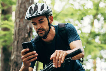 Fahrradfahrer bedient sein Handy