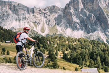 Person hält ein E-Bike auf einem Berg fest