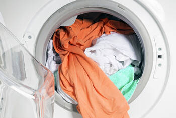 Bunte und weiße Wäsche in einer offenen Waschmaschine
