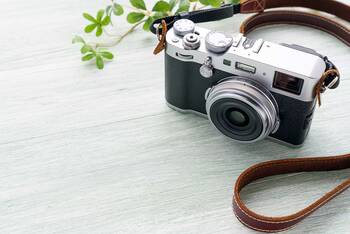 Fotokamera mit Umhängeband aus Leder