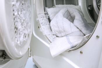 Geöffneter Wäschetrockner gefüllt mit weißer Wäsche