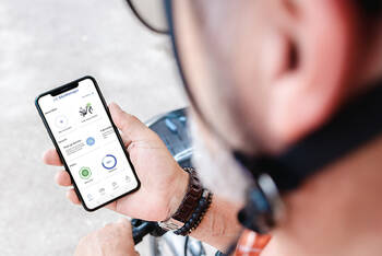 Fahrradfahrer schaut auf Smartphone mit Bikemanager App