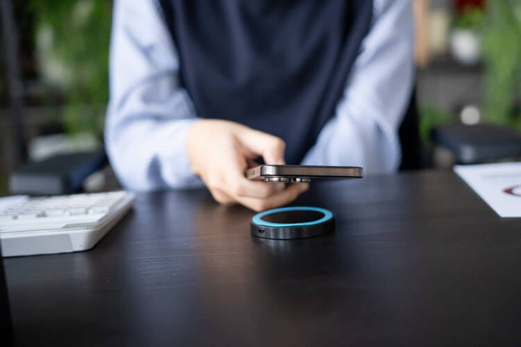 Ein Mann lädt sein Handy kontaktlos. 