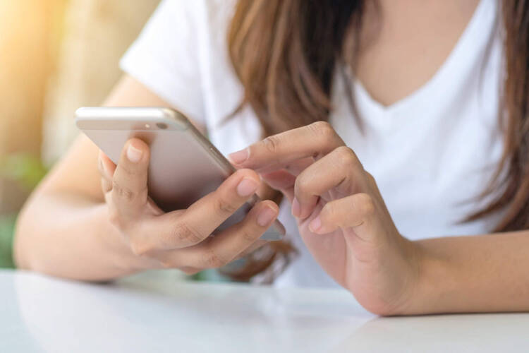 Eine Frau tippt auf ihrem Smartphone herum. 