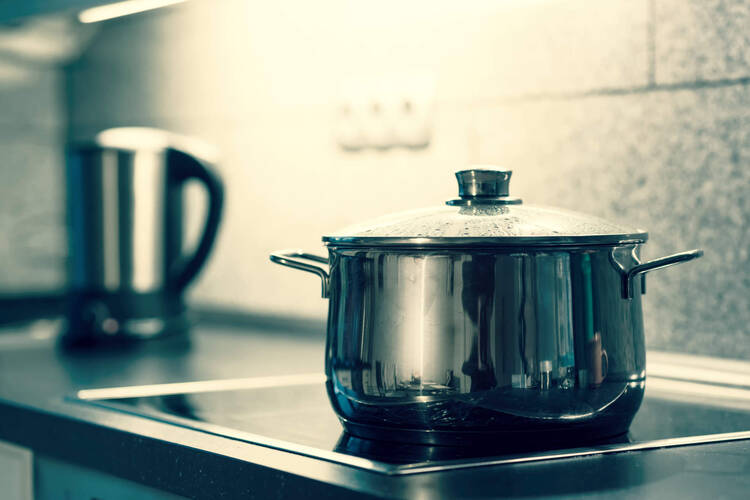 Ein Kochtopf steht auf der Herdplatte.