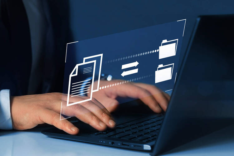 Ein Mann tippt auf dem Laptop.