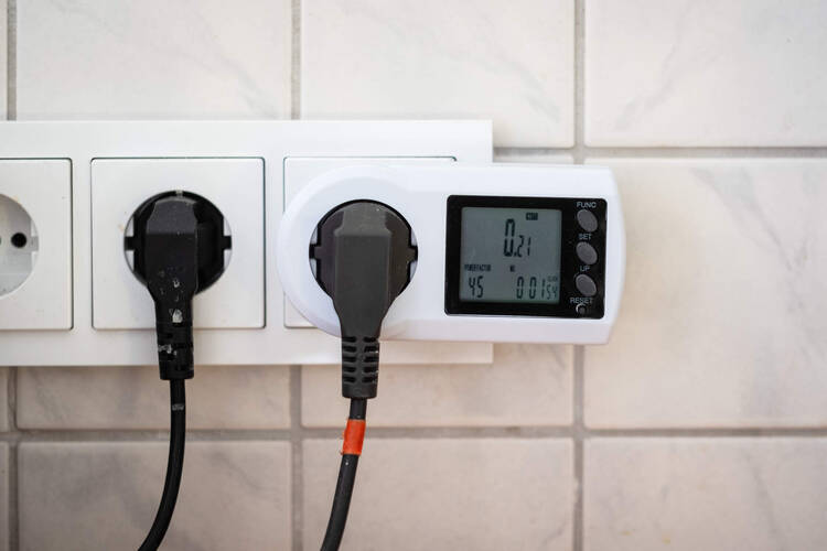 Ein Strommessgerät steckt in einer Steckdose.
