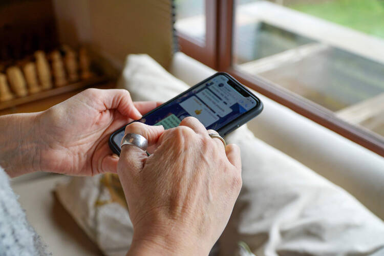 Eine Person tippt im WhatsApp-Messenger auf dem Smartphone. 