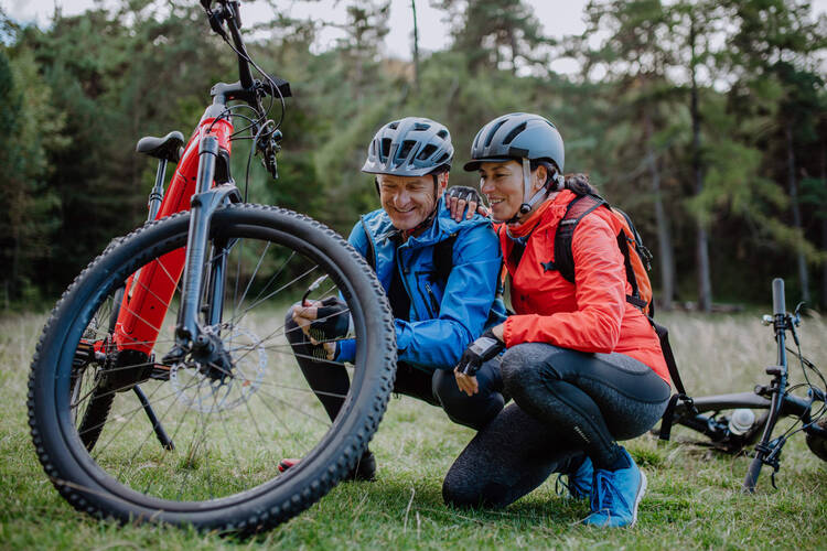 Ein Mann und eine Frauen betrachten ihren E-Bike Reifen