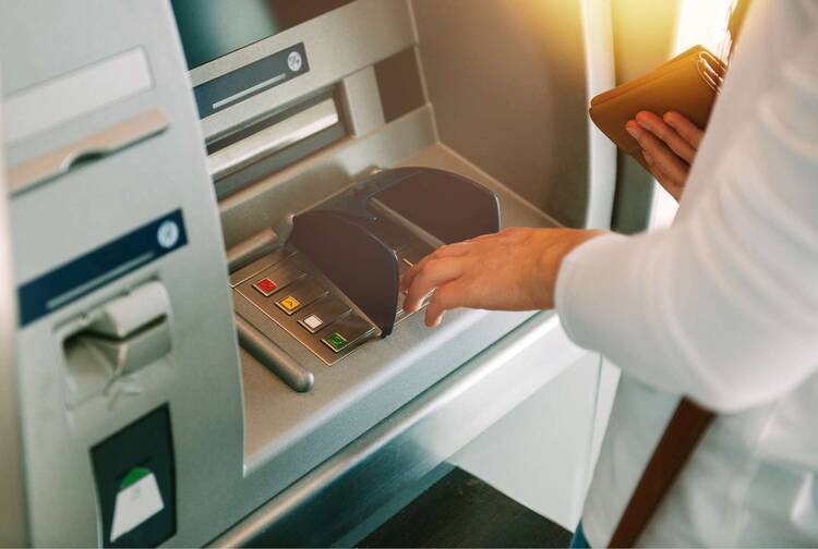 Person bedient Bankautomat