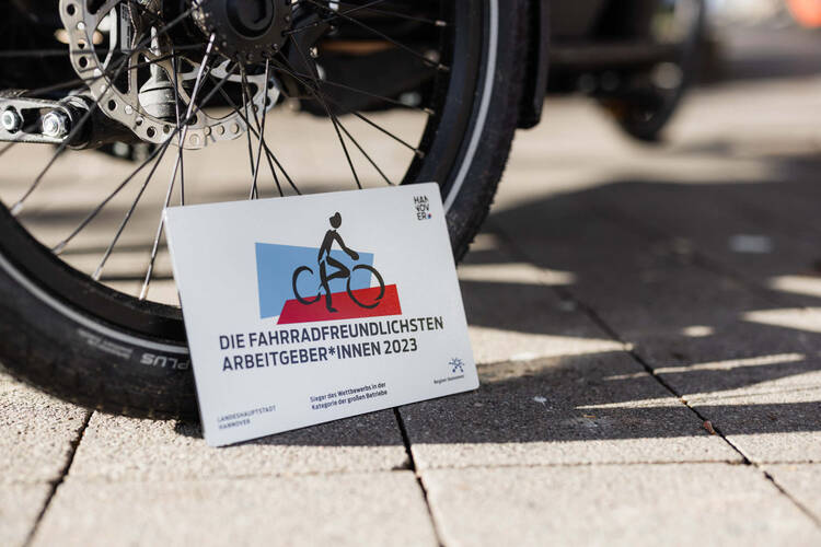 Schild mit Aufschrift "Fahrradfreundlichster Arbeitgeber" steht vor Fahrrad