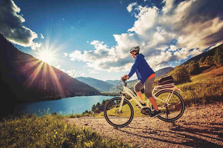Frau fährt Fahrrad an See entlang