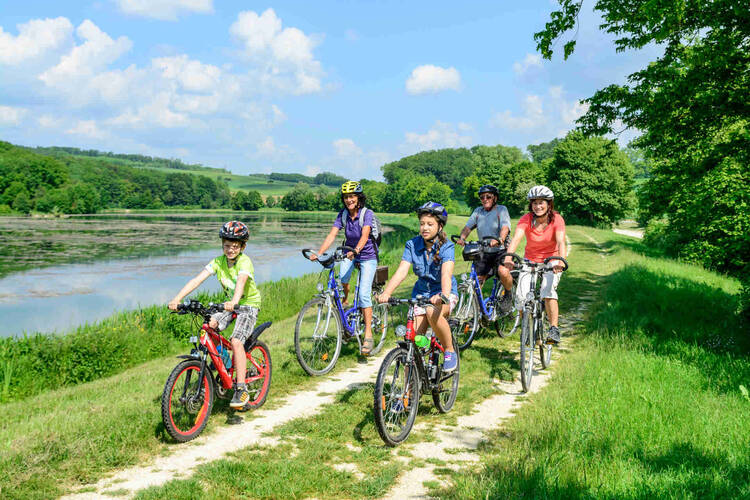Familie fährt mit Kinder neben See