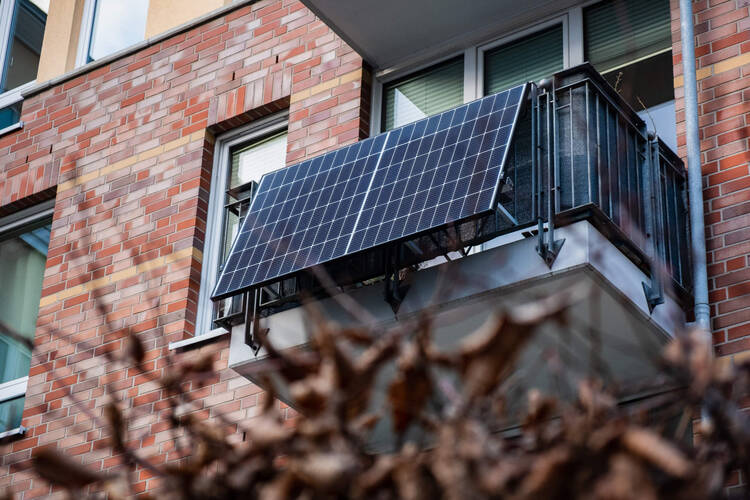 Solarzellen hängen an Balkon eines Wohnhauses