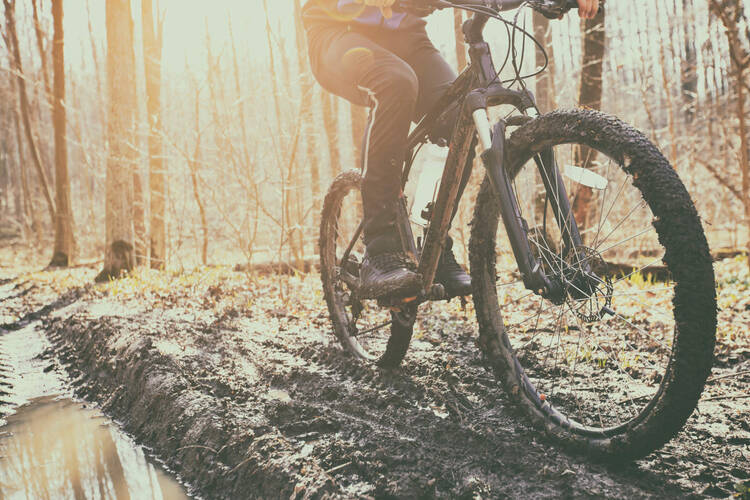 Person fährt bergauf im Schlamm