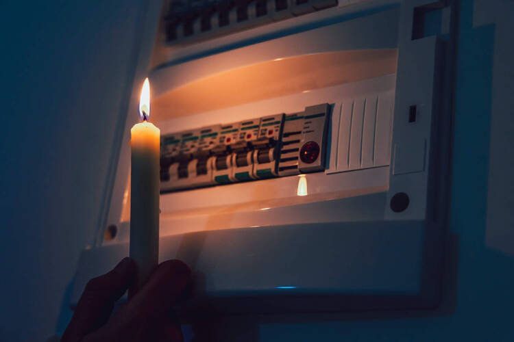 Sicherungskasten wird mit Kerze beleuchtet
