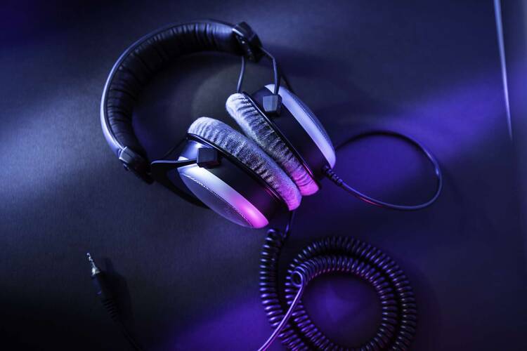 Over Ear Kopfhörer mit Kabel liegen auf blau-lila Untergrund