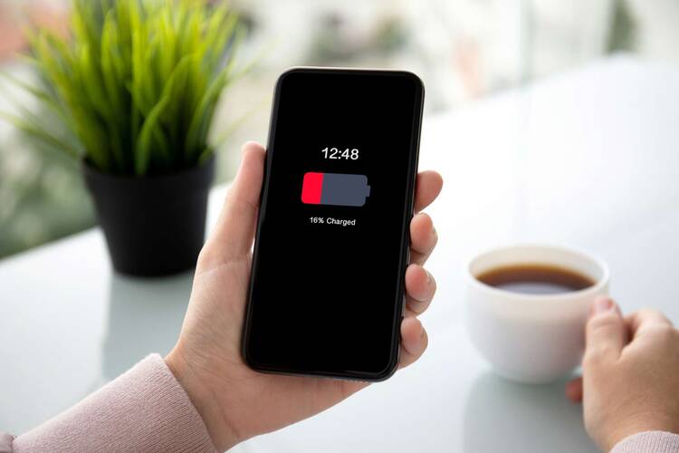 Smartphone mit Anzeige des niedrigen Akkustands in der Hand