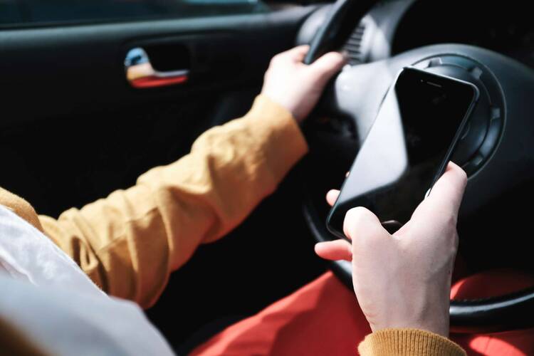 Hand hält Smartphone im Auto