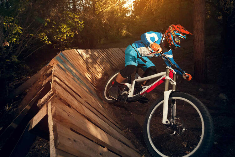 Mounatinbiker fährt Downhill Strecke hinunter.
