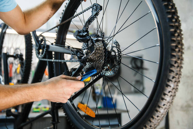 Mann tauscht Kette an Fahrrad aus.