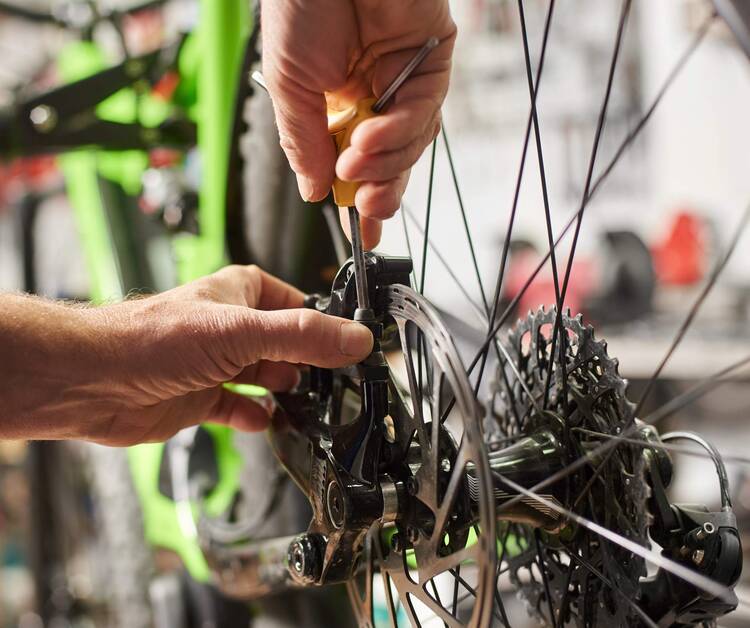 Person schraubt an Fahrradbremse