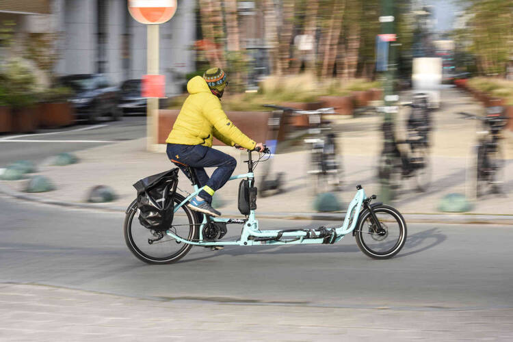 Person fährt auf Cargo-Bike durch die Stadt