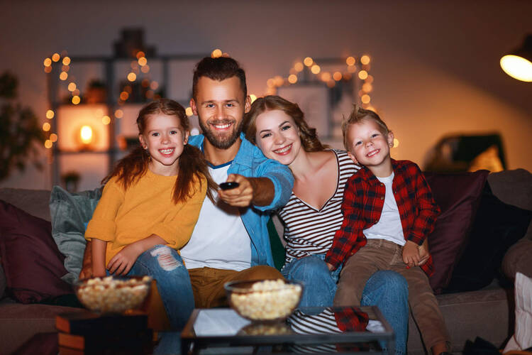 Familie sitzt vor Fernsehen und schaut Film