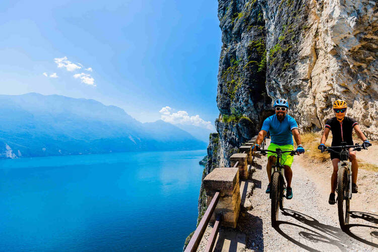 Mann und Frau fahren Radweg am Gardasee entlang