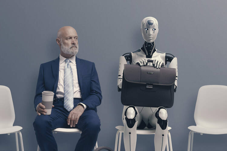 Mann sitzt neben Roboter