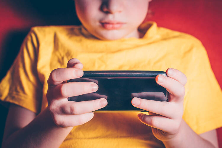 Kind sitzt vor Smartphone