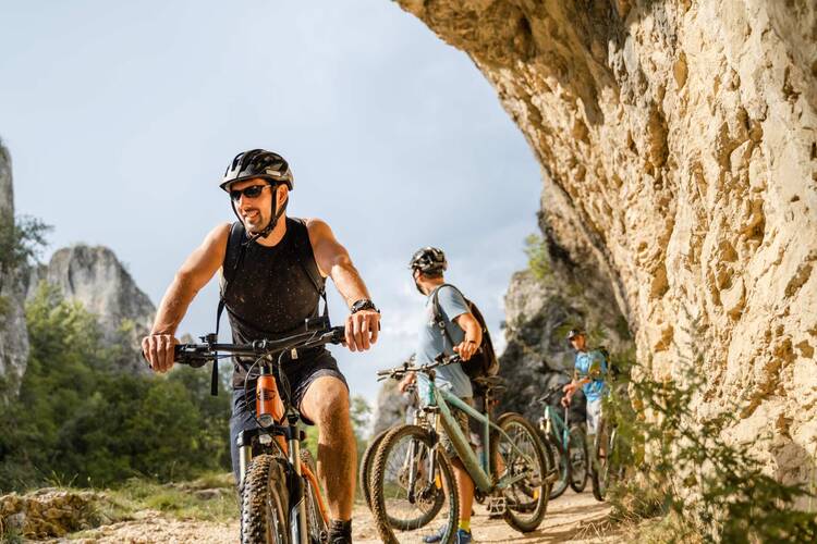 Fahrradfahrer mit E-Mountainbikes in den Bergen auf Tour
