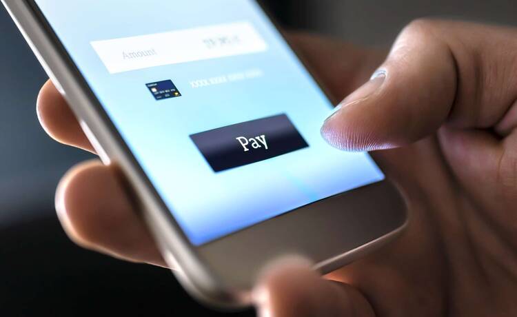 auf einem Smartphone wird ein Button mit der Aufschrift Pay gedrückt