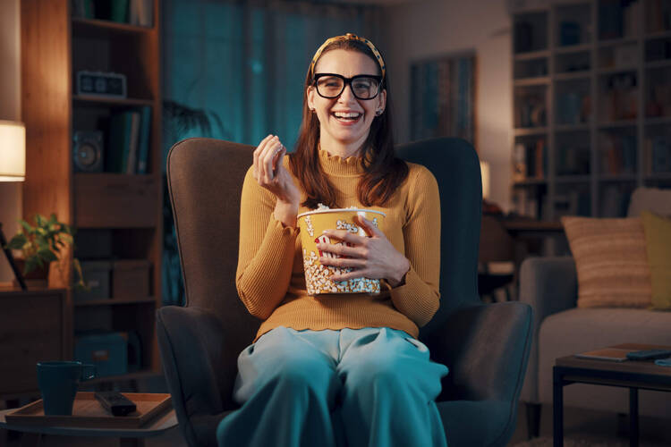 Frau schaut Film mit Popcorn