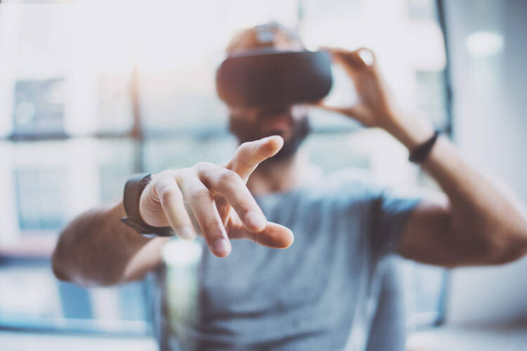 Mann zeigt auf etwas und hat VR-Brille auf