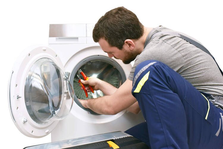 Mann repariert Waschmaschine