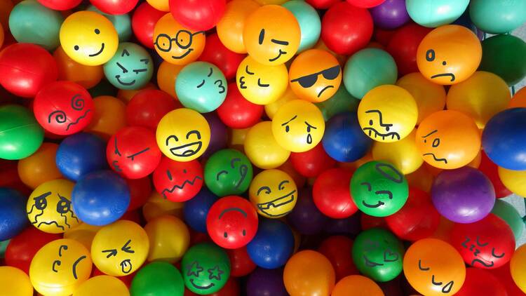 Bunte Bälle mit aufgemalten Emoji-Gesichtern