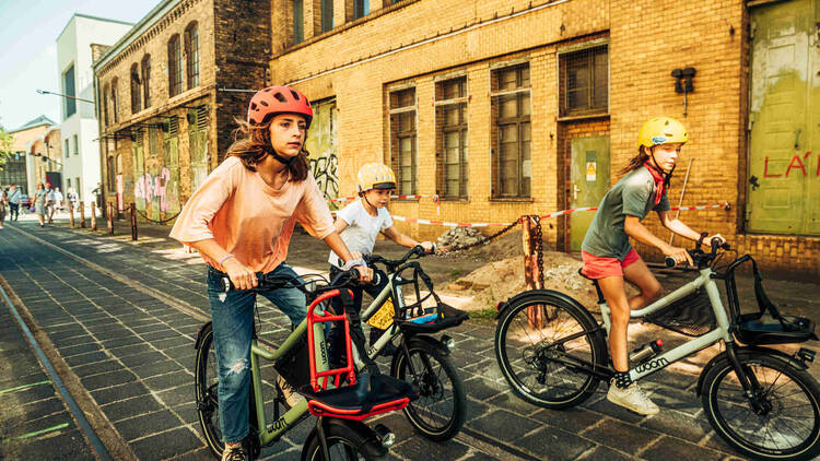 Kinde rund Jugendliche fahren auf Fahrrädern durch die Stadt