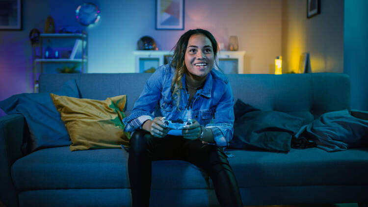Frau spielt auf der Couch Spielekonsole