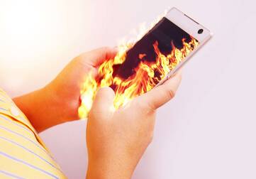 ein brennendes Smartphone wird in der Hand gehalten 