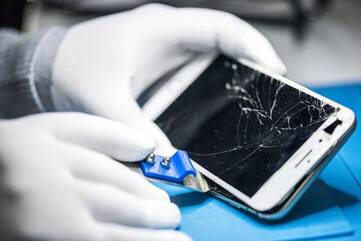Person repariert Smartphone mit kaputtem Glas