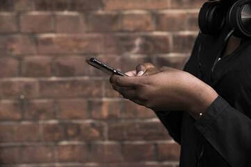 Person hält schwarzes Smartphone in beiden Händen